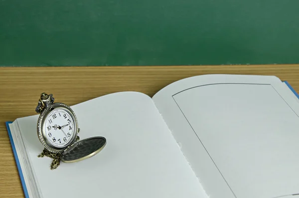 Pendent clock on blank open book — Stock Photo, Image