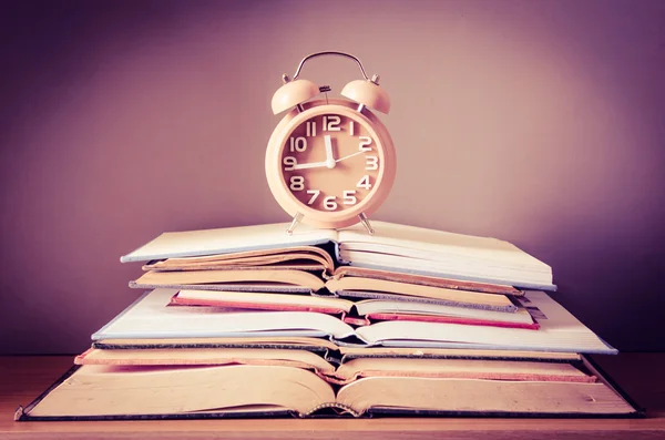 Çalar saat açık kitap yığını üzerinde — Stok fotoğraf