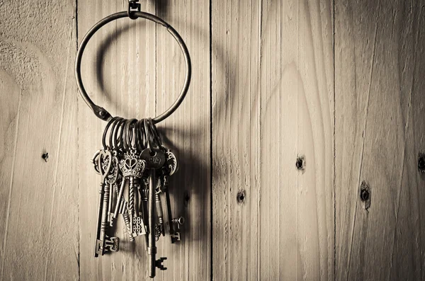 Vintage key hanging on wooden wall background — стоковое фото