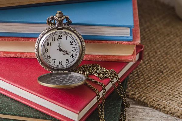 Zak of tegenhanger horloge op achtergrond oude boeken — Stockfoto