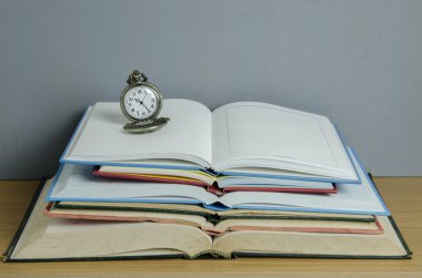 Pendent Saat Açık kitap yığını üzerinde