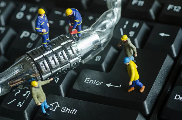 Personas en miniatura tratan de desbloquear la llave de bloqueo de seguridad de metal — Foto de Stock