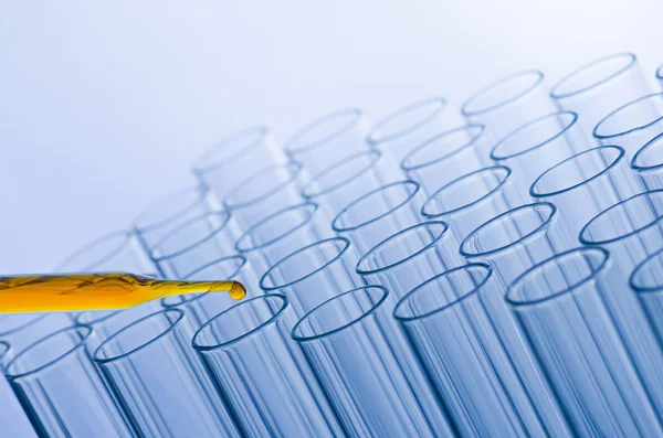 Pipeta de laboratório de ciência com queda no fundo do tubo de ensaio — Fotografia de Stock