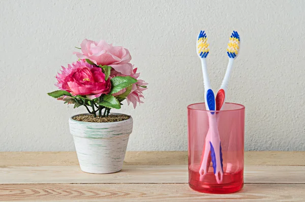 Couple toothbrush in glass on wooden table — Stock Photo, Image