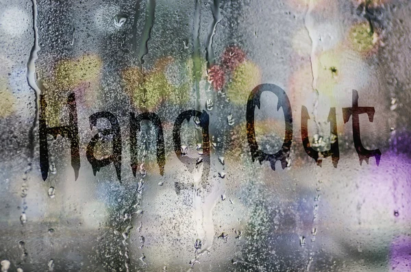 Natural water drops on glass window with the text "Hang Out" — Stock Photo, Image