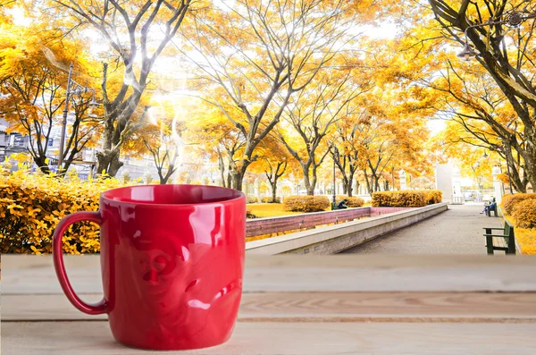 Rote Kaffeetasse auf Parkhintergrund — Stockfoto