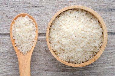 Beyaz ahşap zemin üzerinde bir kapta çiğ pirinç