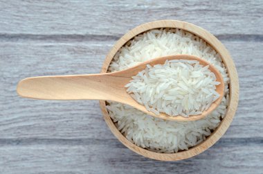 Beyaz ahşap zemin üzerinde bir kapta çiğ pirinç