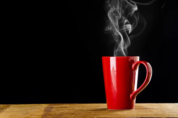 Tasse de café rouge avec de la fumée sur fond noir — Photo