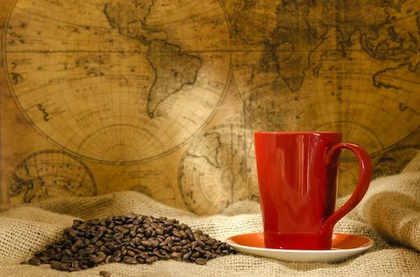 Rote Kaffeetasse und Kaffeebohnen herum — Stockfoto