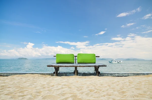 Grüne Sitzbank oder Holzbank mit Meerblick und wolkenverhangenem Himmel — Stockfoto