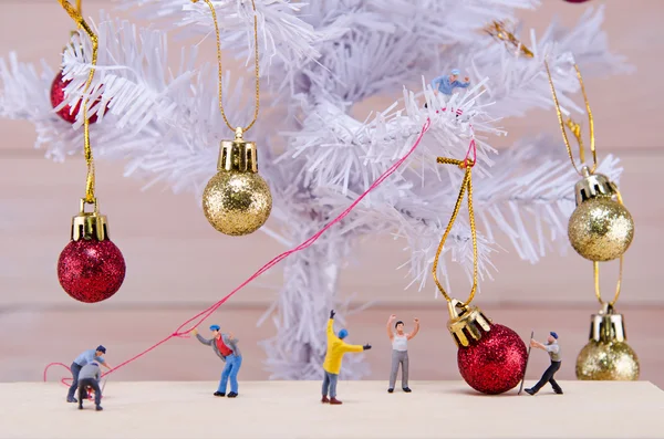 Personas en miniatura tratan de adornar el árbol de Navidad — Foto de Stock