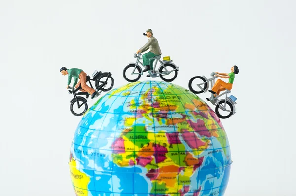 Miniature people riding bicycle around the globe — Stock Photo, Image