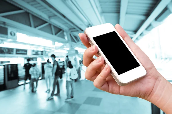 Woman hand holding the phone tablet on blur event background — Stock Photo, Image