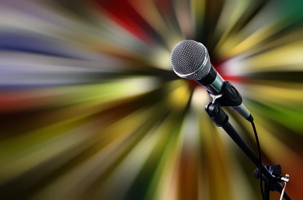 Mikrofon na jevišti s pohyblivými světlé pozadí — Stock fotografie