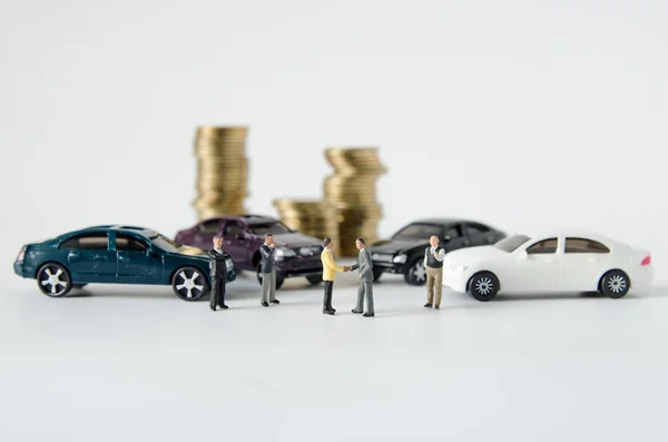 Acordo de equipe de empresário miniatura com pilha de moedas backgro — Fotografia de Stock