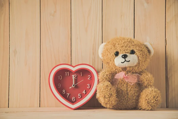 木製テーブルの上の時計の赤いハートとクマのぬいぐるみ — ストック写真