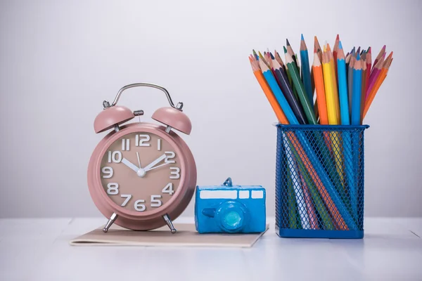 Цветной карандаш и будильник на деревянном столе — стоковое фото