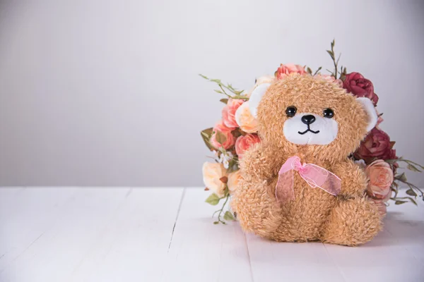 Nallebjörn med ros på vita träbord — Stockfoto