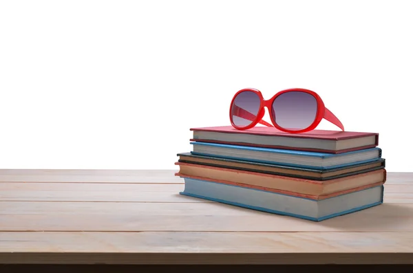 Gafas de sol rojas en la pila de libro aislado sobre fondo blanco —  Fotos de Stock