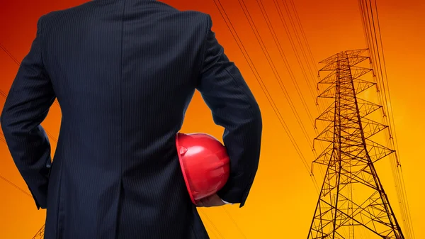 Business man in black suite holding red safety helmet with const — Stock Photo, Image