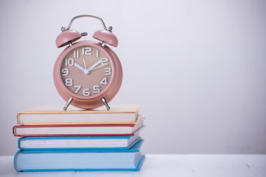 çalar saat açık kitap yığını üzerinde