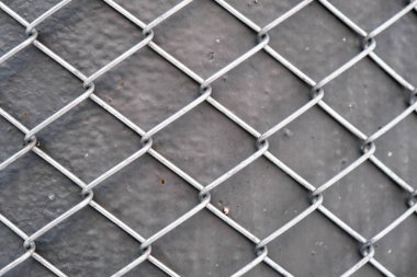 metal grid pattern and texture background, abstract industrial metallic surface, shiny aluminum mesh on grey textured iron pole, steel wire security fence, isolated outdoors, grunge backdrop