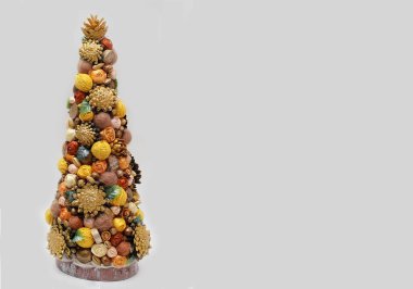 Çam kozalaklı, kestaneli ve saten kurdeleli el yapımı Noel ağacı. Tatil için dekor. Metnin için boş yer.