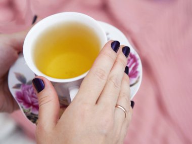 Bir kadının elinde bir fincan çay var. Rahatlama zamanı. Çay molası.