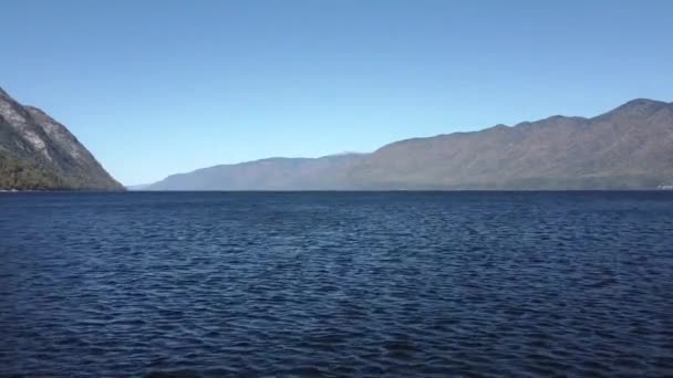 Вид на горное озеро. Летающий над водой Телецкое озеро, Алтай — стоковое видео