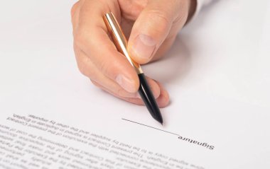 Sözleşme imzalama konsepti. Belgenin üzerinde altın kalemle iş adamı eli, imza için boşluk