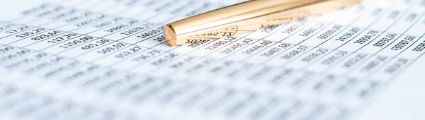 golden pen over financial document extra close up, banner. accounting concept