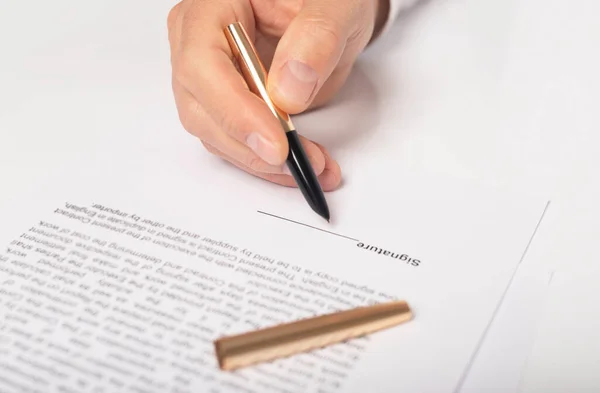 Contract signing concept. Businessman hand with pen over document, space for signature, closeup.