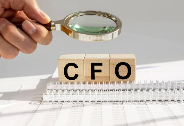CFO acronym built with letter cubes on office table, searching for chief financial officer concept