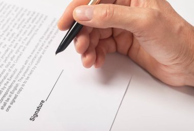 Sözleşme imzalama konsepti. Belgeyi yakın plan üzerine yazan iş adamı eli.