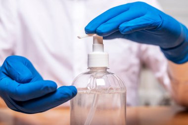 Eldiven takan ya da salgın sırasında el dezenfeksiyonu için dezenfektanı kullanan erkek eller. Ellerini sterilize et.