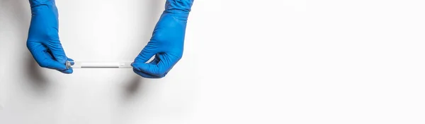 Тестова лабораторія в руках лікаря в рукавичках над білим банером з копіювальним простором для тексту — стокове фото