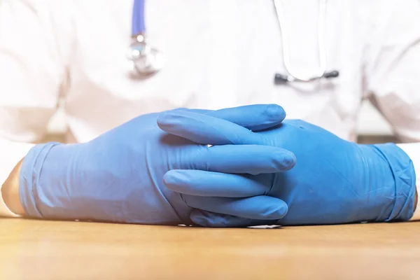 Ο γιατρός βάζει γάντια στο τραπέζι από κοντά. ιατρικός χώρος — Φωτογραφία Αρχείου