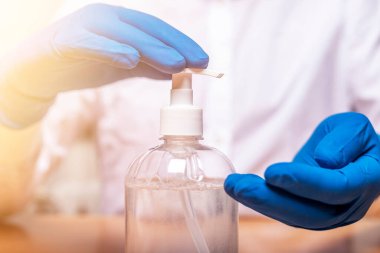 Eldiven takan ya da salgın sırasında el dezenfeksiyonu için dezenfektanı kullanan erkek eller. Ellerini sterilize et..