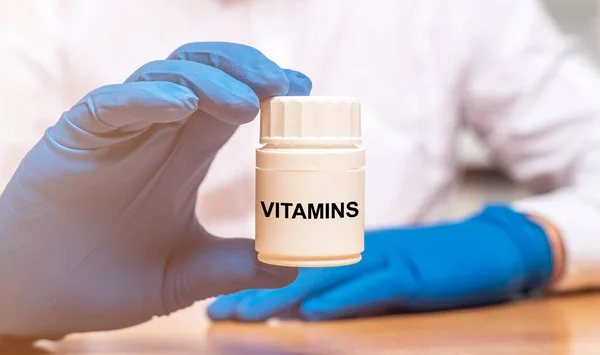 Vitamine Parola Sul Barattolo Bianco Nelle Mani Del Medico Vicino — Foto Stock