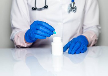 Kadın doktor eli hastalıkları tedavi etmek için bir avuç kapsül ya da hap gösteriyor. Vitamin takviyesi. İlaç reçetesi..