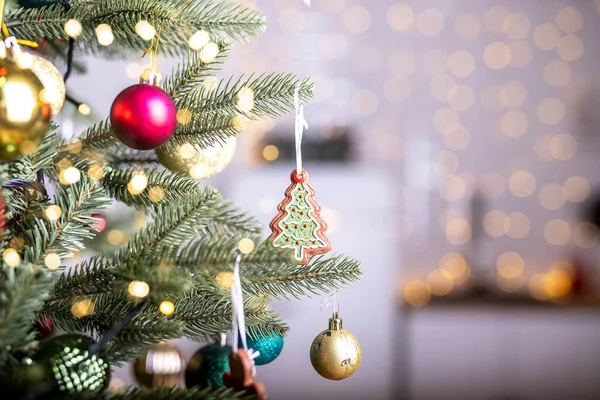 Close up view of beautiful fir branches with shiny decorations, baubles, xmas ornaments and lights, christmas holidays background.