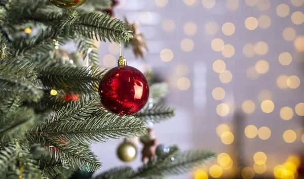 Mücevherleri ve topları olan güzel ilk ağaç dallarının, xmas süslemelerinin, oyuncakların, ışıkların ya da çelenklerin olduğu güzel manzarayı kapat..