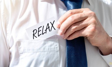 Rahatla, beyaz kağıt üzerine el yazısıyla yazılmış metin, iş adamı tarafından cebe konuldu, dinlenme zamanı ertelendi, dinlenme konsepti