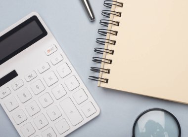 Hesap makinesi, defter, kalem ve büyüteci olan bir iş. Muhasebe kavramı.
