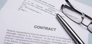 Ofis masasında kalem ve gözlüklerle anlaşma ya da anlaşma. Yatay fotoğraf.