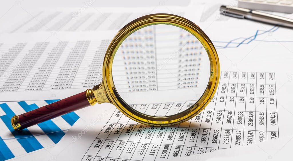 Business financial analysis and research concept. Magnifier on documents.