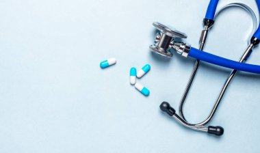 Steteskop, hap, kapsül ve metin veya kopyalama alanı içeren tıbbi mavi pankart.