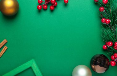 Köknar dalı, kırmızı böğürtlen, tarçın, xmas süslemeleri veya topları ve metin veya kopyalama yeri çerçeveli derin yeşil Noel arkaplanı.
