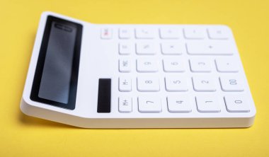 Sarı arkaplanda hesap makinesinin yan görünümü.